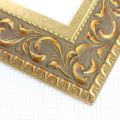 A large, reverse curve profile frame with an intricate leaf design bordered by a geometric outer edge and beaded inner lip. A matte and gold foil base features bronze patina for added depth on the topmost points of the design. Strong, solid wood construction.
3.25 " width: ideal for large and extra large images.